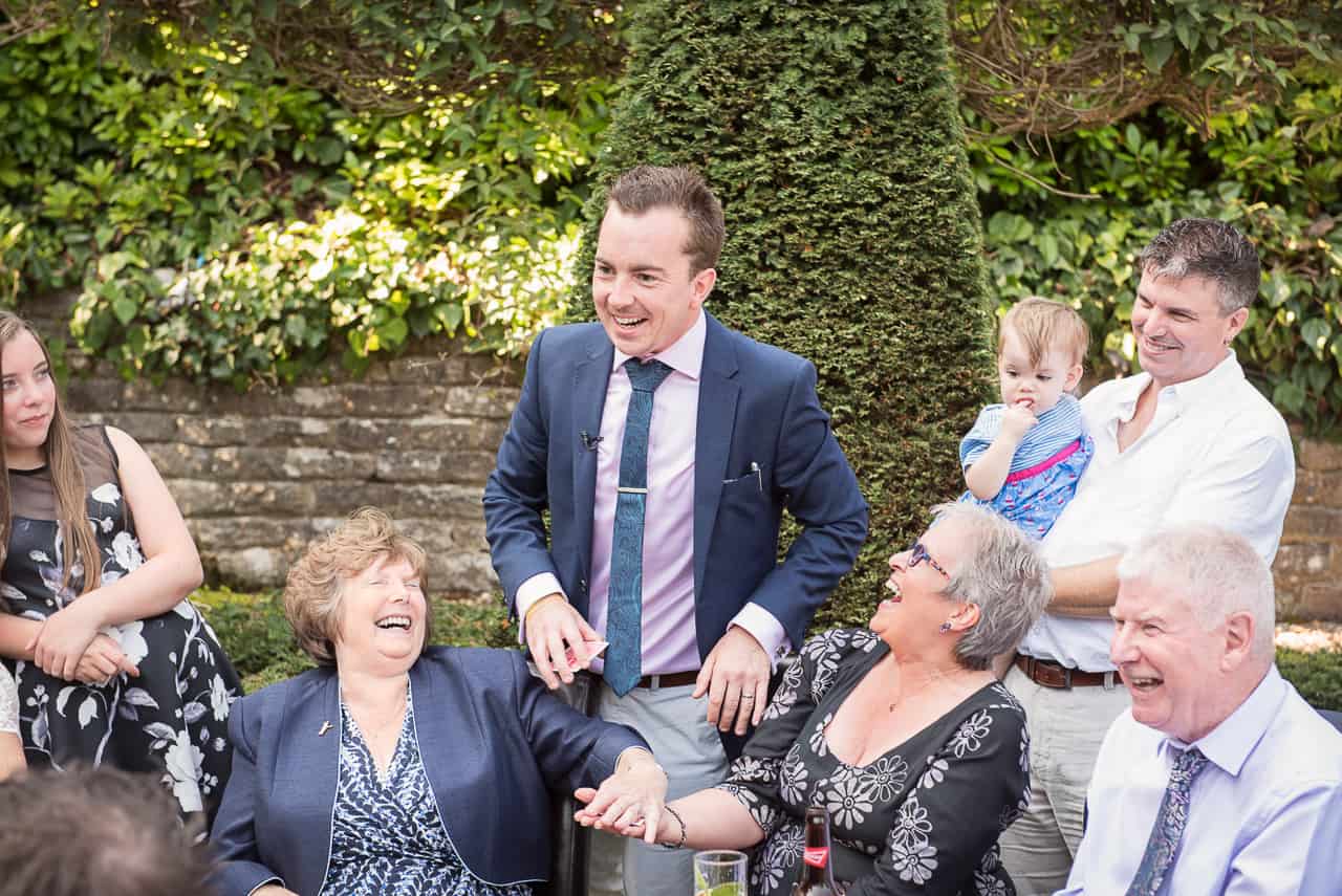 Wedding party are laughing at Dorset magician James Maidment during the drinks reception at Italian Villa
