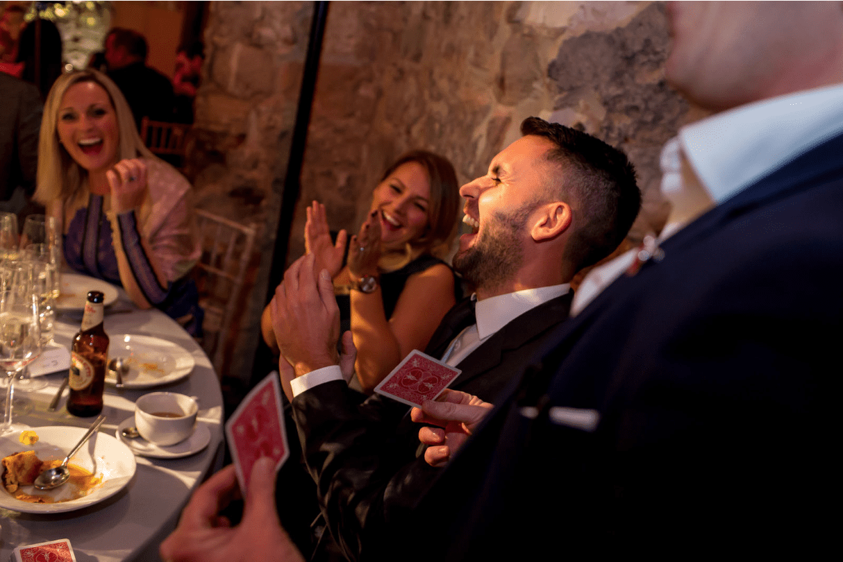Wedding guests clapping at magician James Maidment for an amazing trick.